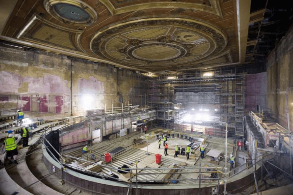 inside Alexandra Palace, featuring workmen in high vis jackets