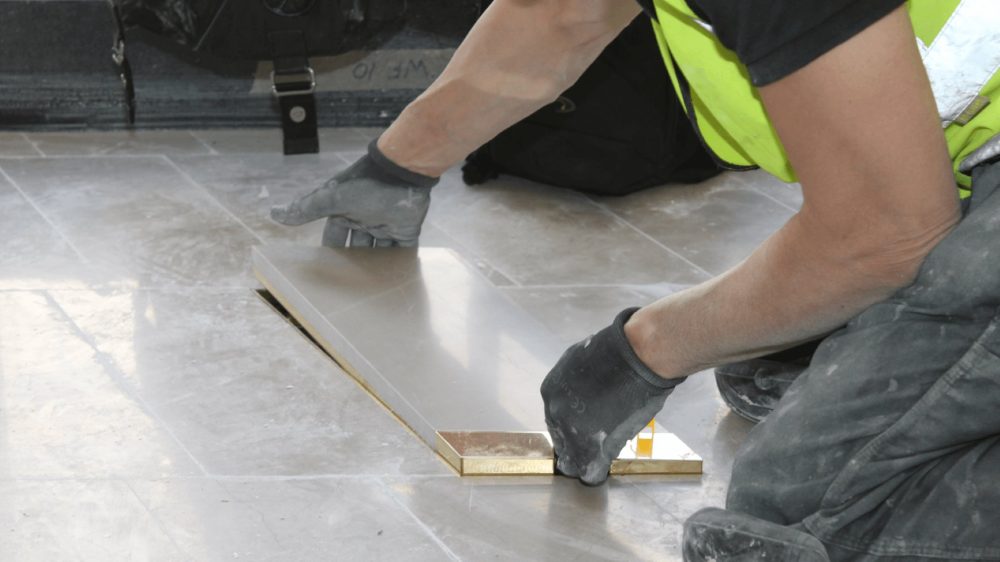 a stone floor box being installed, fitting the final panel