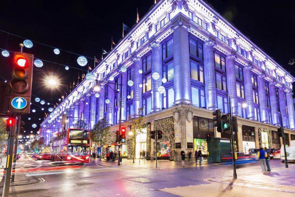 wide shot of selfridges lit up at night-time